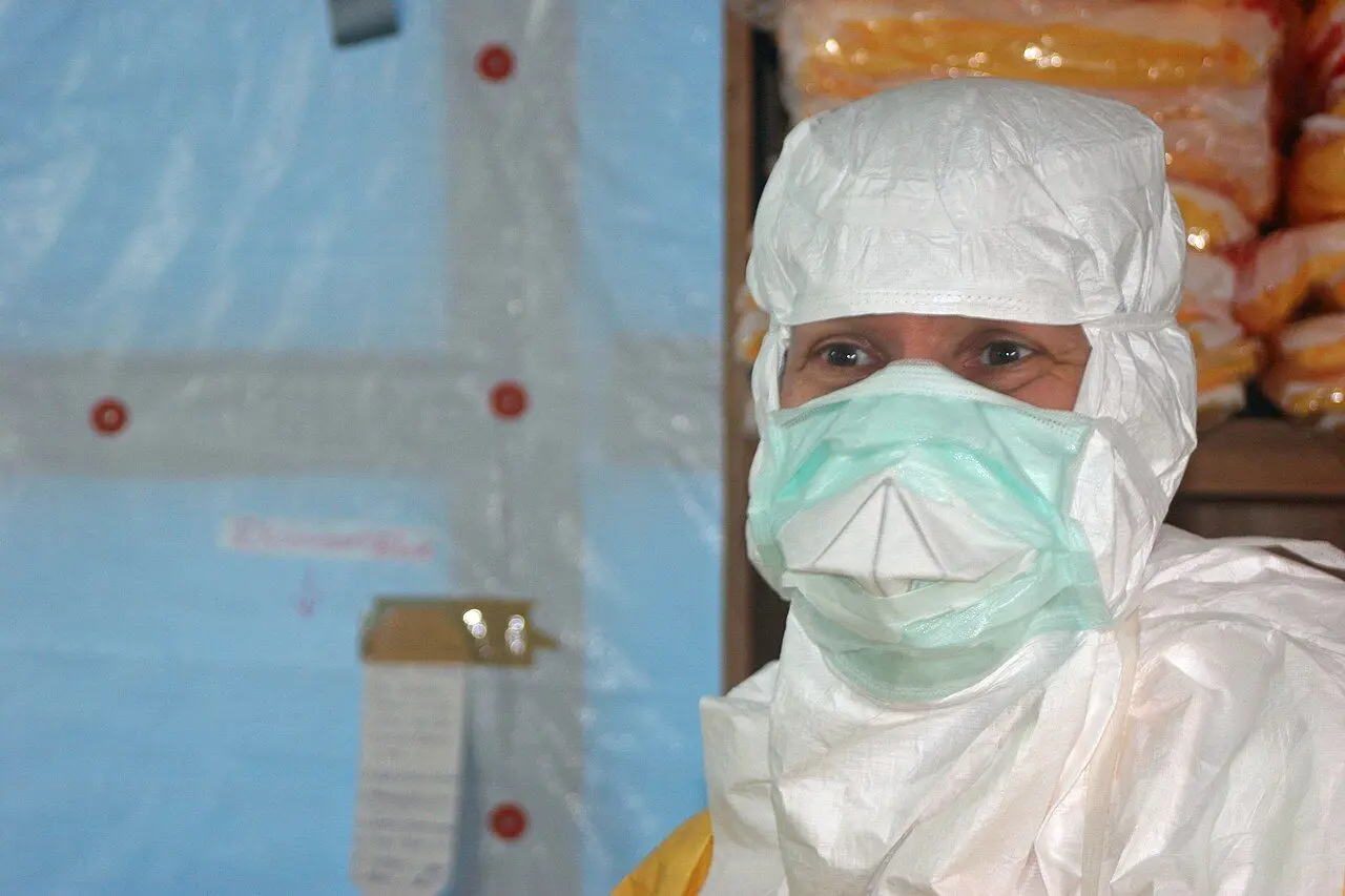 Health workers wearing personal protective equipment entering an Ebola treatment centre